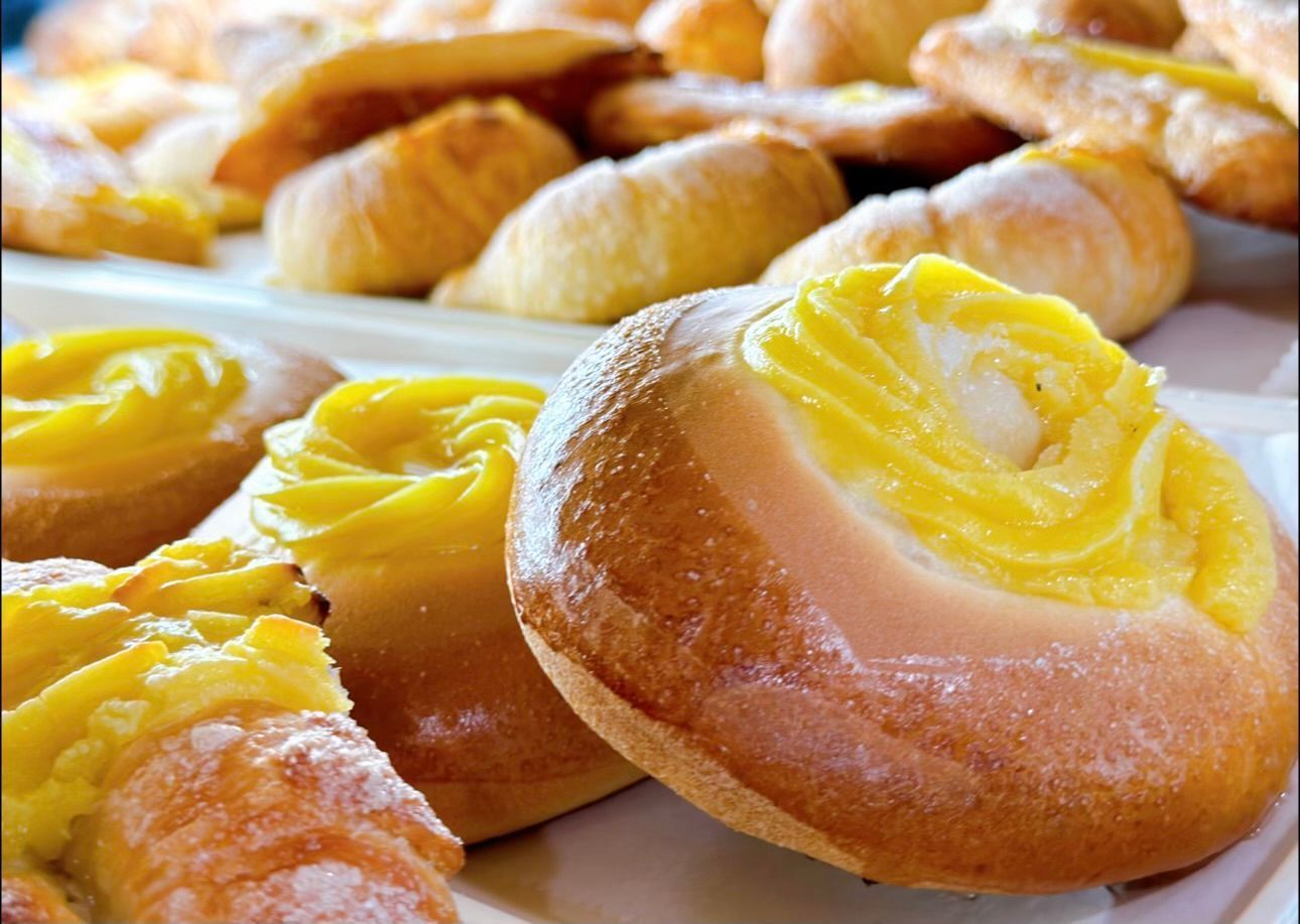 A bunch of pastries with yellow frosting on them