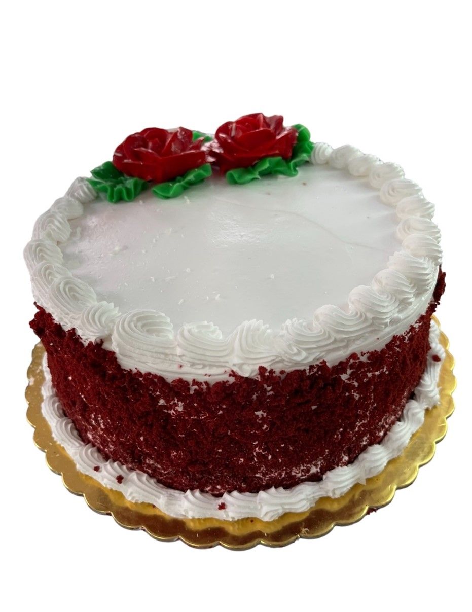 A red velvet cake with white frosting and red roses on top