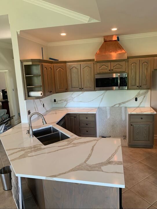 A kitchen with granite counter tops , stainless steel appliances , and wooden cabinets.