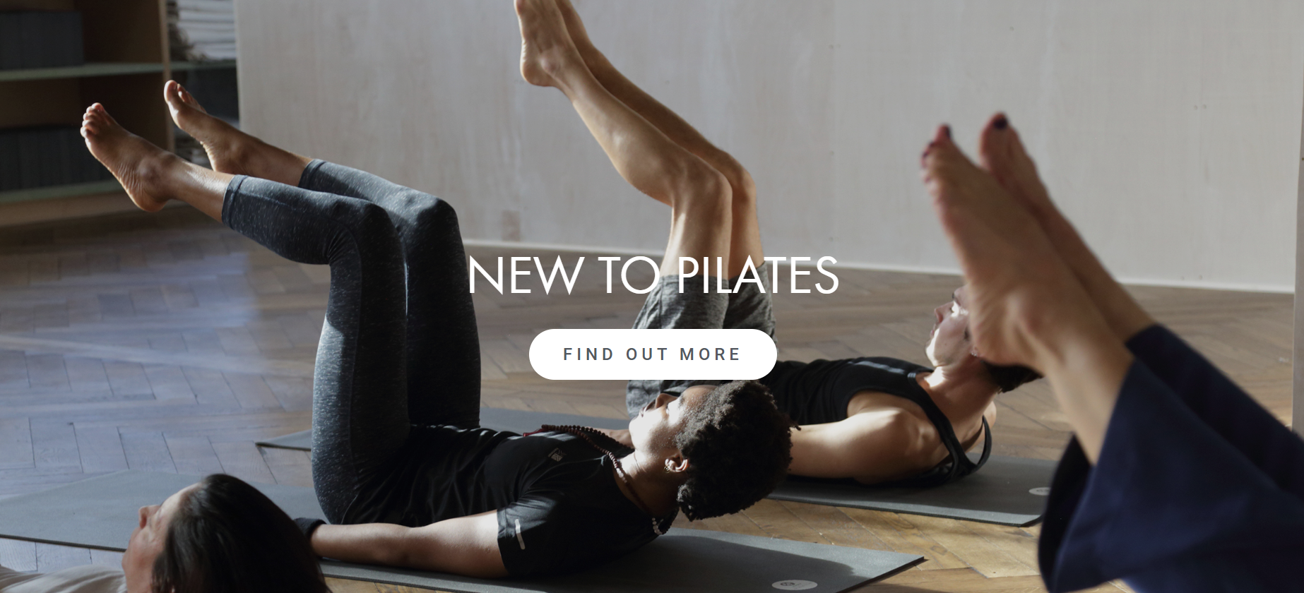 Two women are doing pilates on a yoga mat.