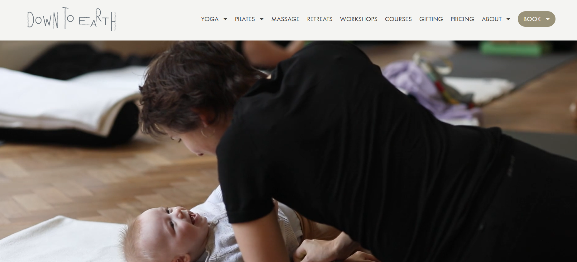 A woman is laying on the floor playing with a baby.