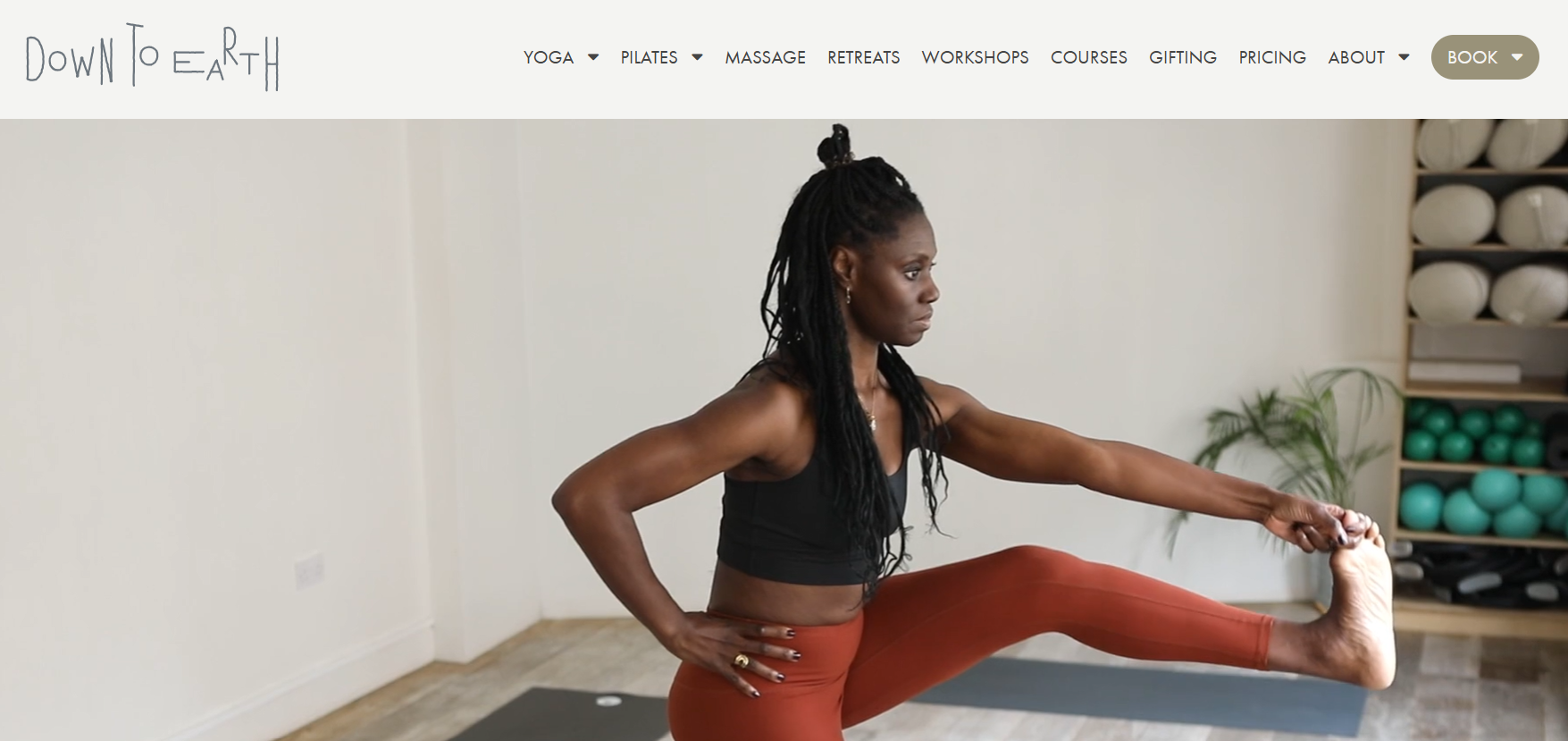 A woman is stretching her legs on a yoga mat.