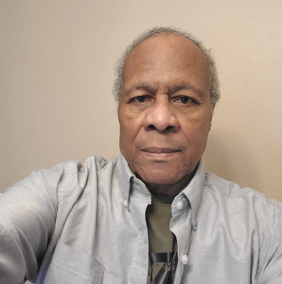 A doctor is touching the shoulder of a patient in a hospital.