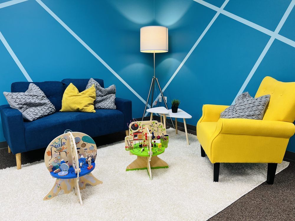 A living room with a blue couch and yellow chairs