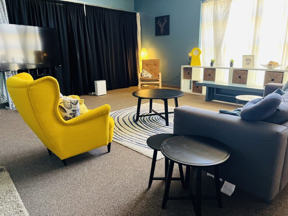 A living room with a couch , chairs , tables and a television.