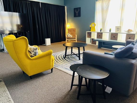 A living room with a couch , chairs , tables and a television.