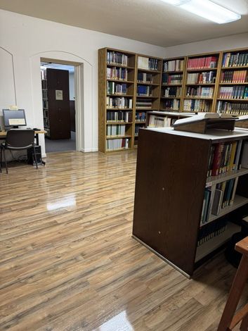 A library with lots of books on shelves and a desk