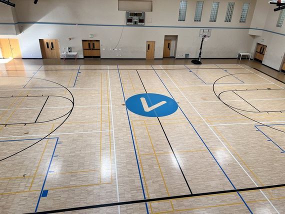A basketball court with a blue circle with the letter v on it