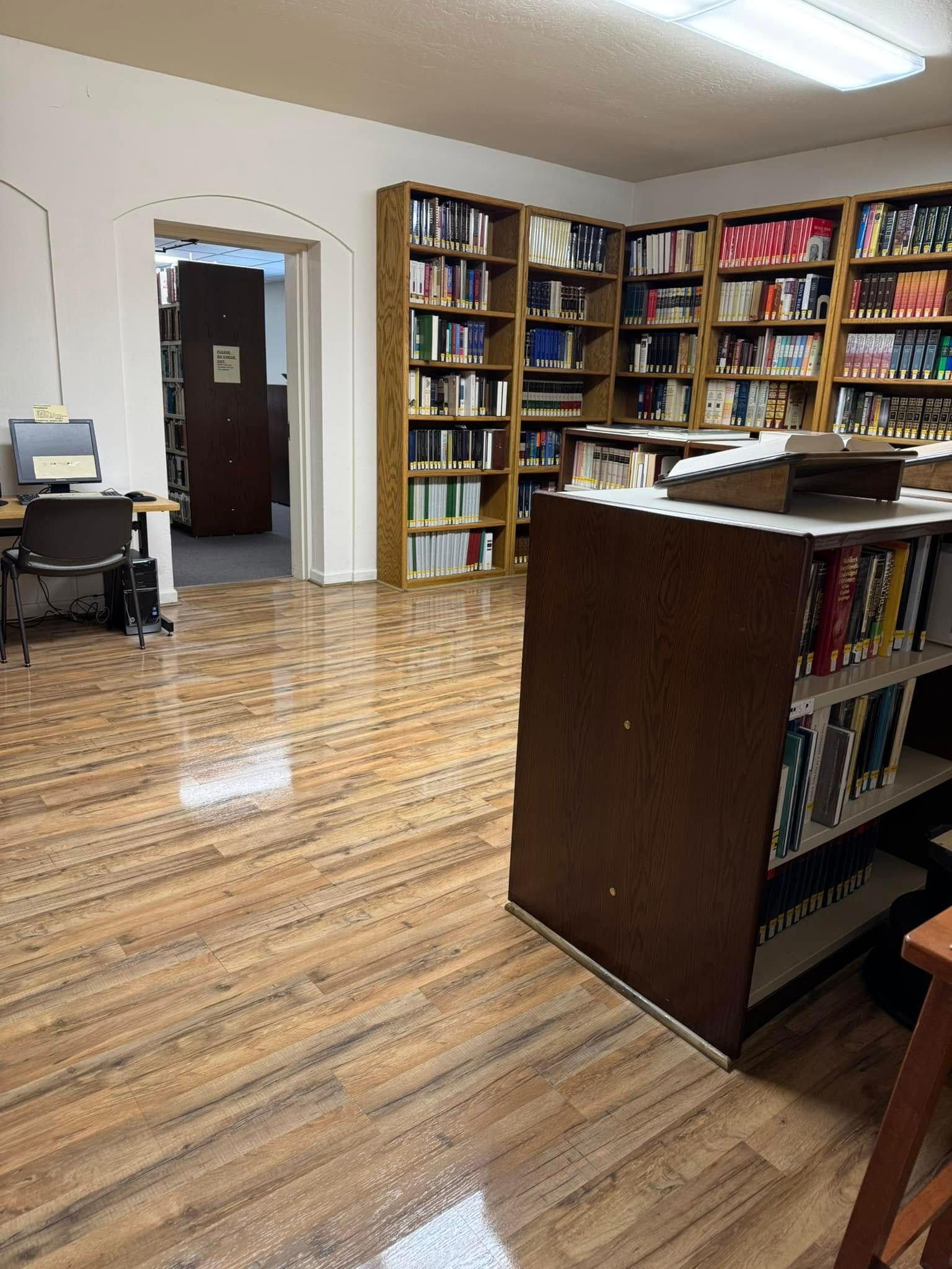A library with wooden floors and lots of books on shelves
