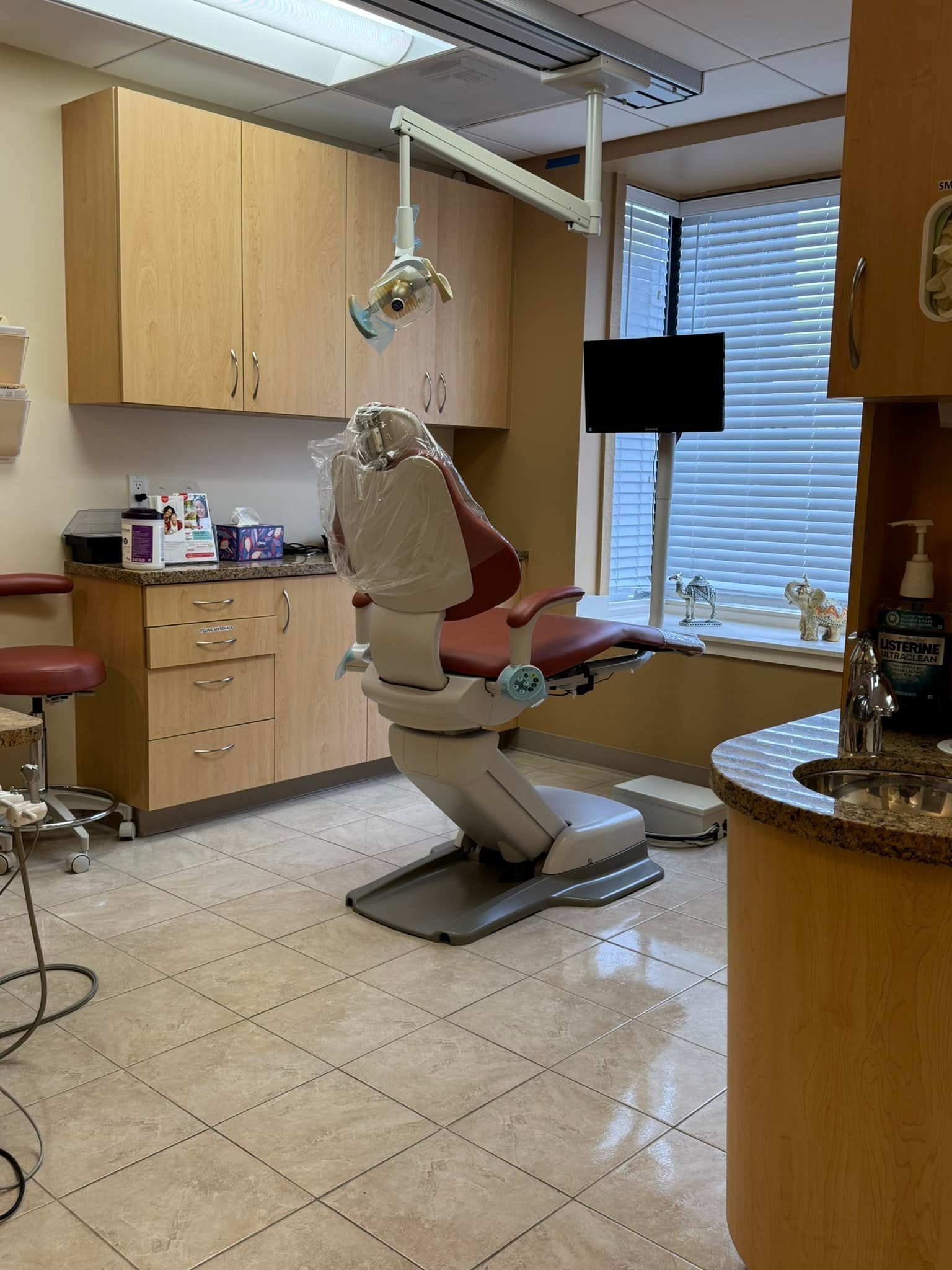 A dental office with a dental chair and a sink.