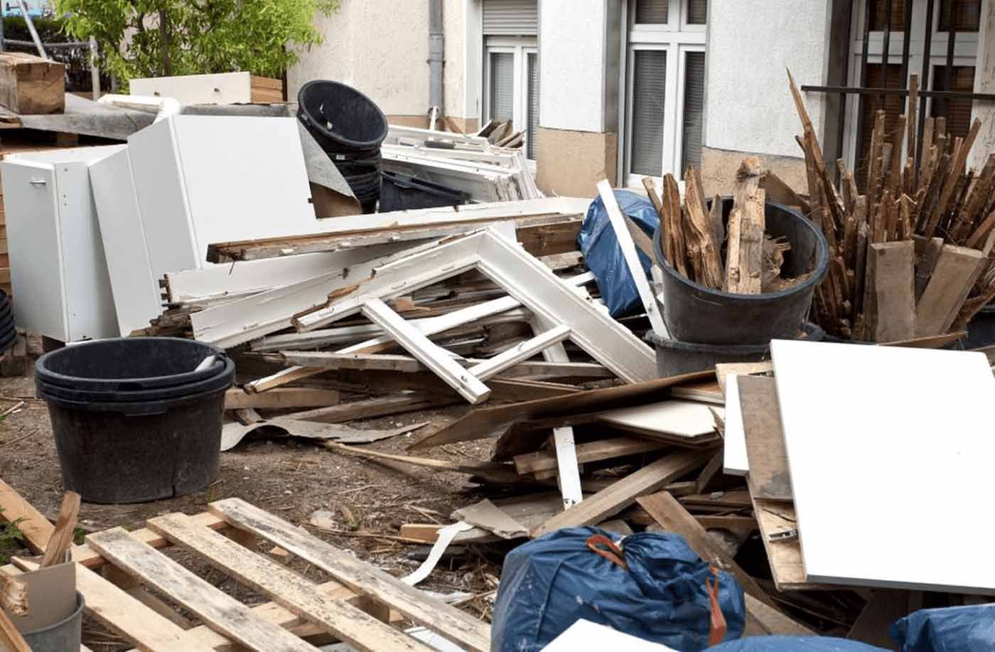 A pile of wood and trash is sitting in front of a building.