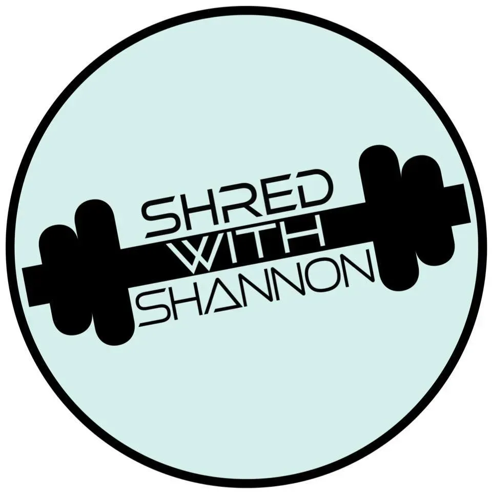 The logo for shred with shannon is a circle with a dumbbell in it.