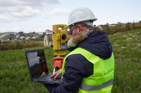A land surveyor conducting modern topographic surveying