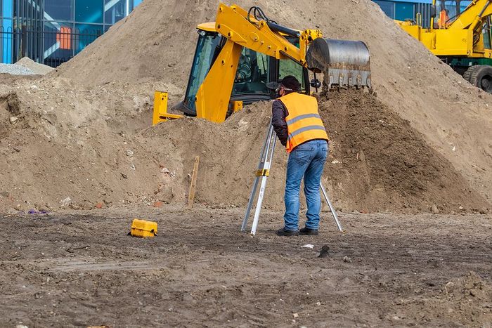 worker using surveying equipment and GPS at the construction site