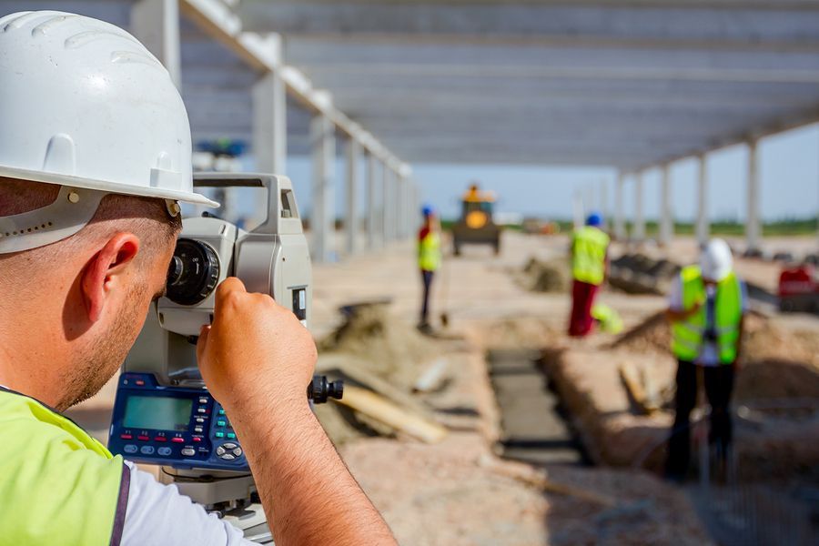 a licensed surveyor using total station at construction site