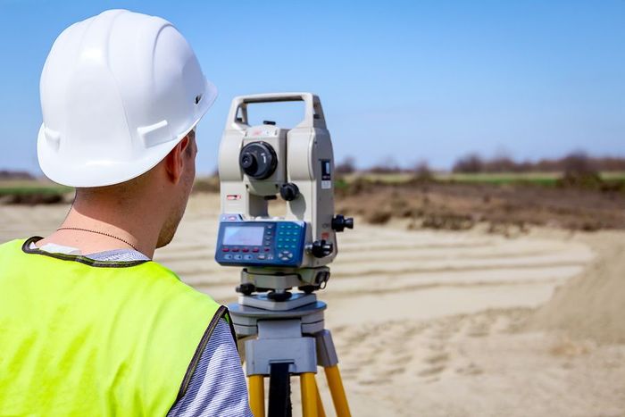 land surveyor working with total station on a building site