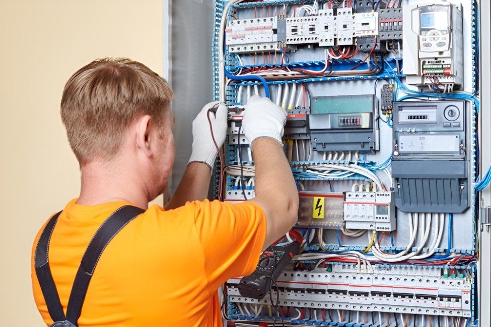 A Man is Working on an Electrical Panel With a Screwdriver — Riselectrical In Currumbin Waters, QLD
