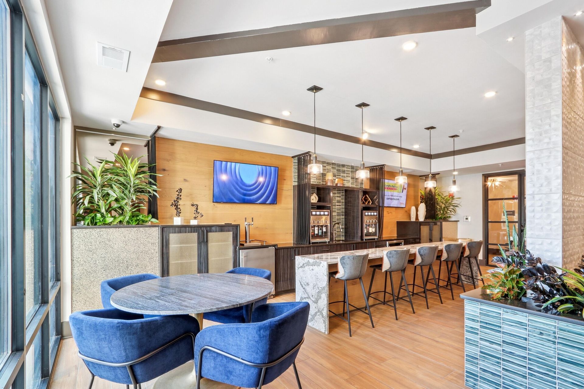Interior of a modern resident lounge with a bar, stools, and blue chairs. Get to know one of the best apartments in Louisville and imagine yourself settling in. Bring your furry companion home to pet-friendly apartments in Louisville, KY you’ll both love.