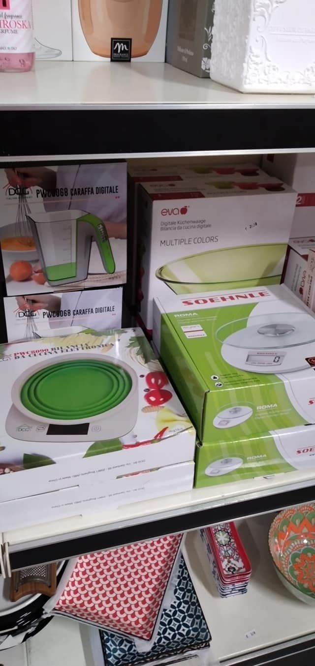 Uno scaffale pieno di scatole e una bilancia verde.