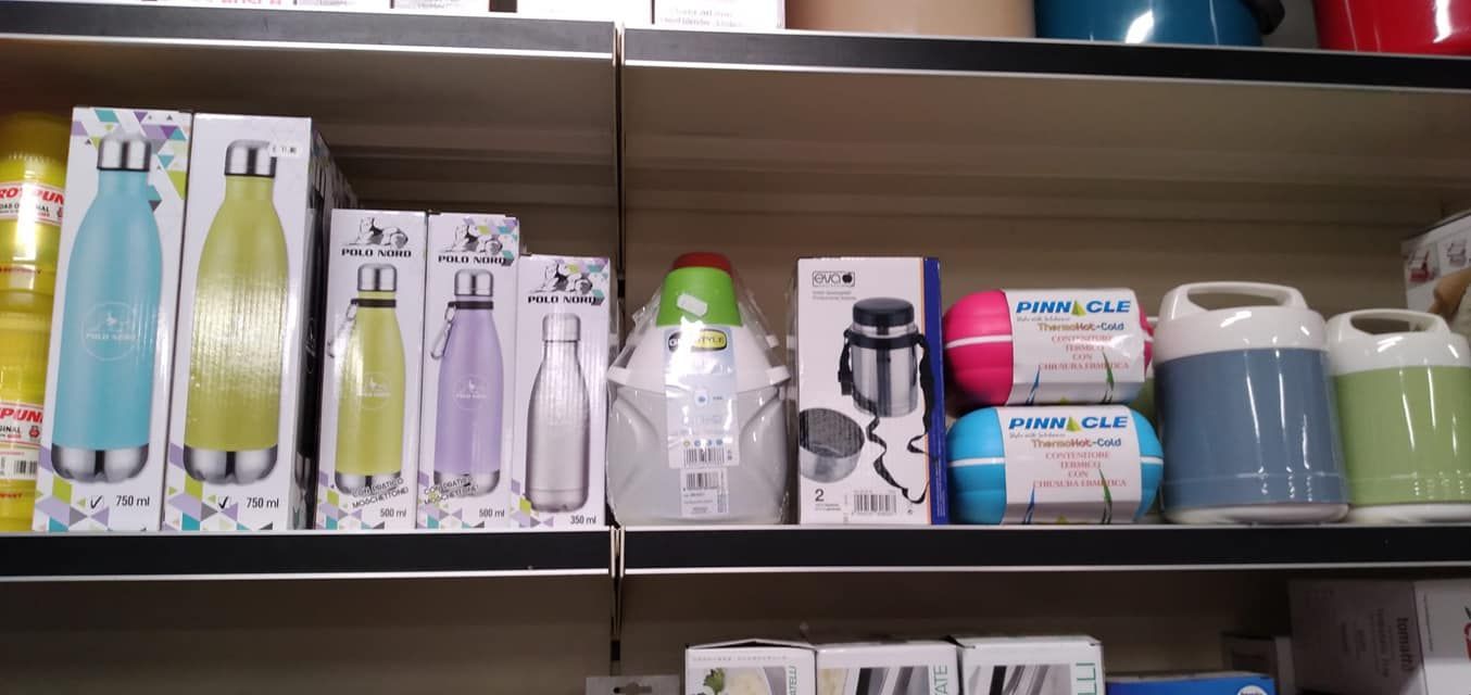 Uno scaffale pieno di bottiglie e tazze di vario tipo