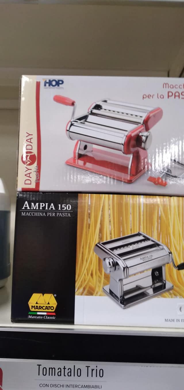 Una macchina per la pasta è appoggiata su uno scaffale accanto a una scatola.