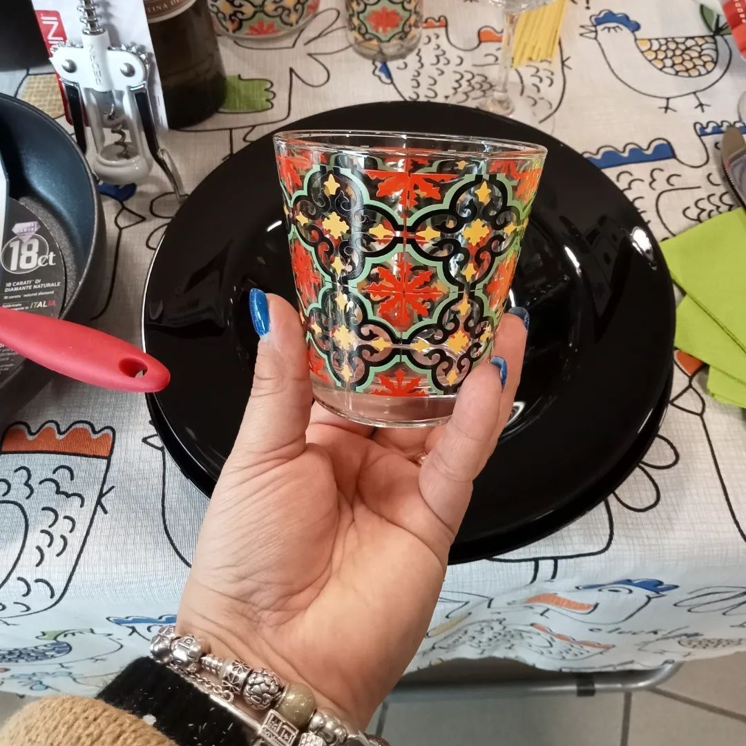 Una persona che tiene un bicchiere davanti a un piatto su cui è scritto 18