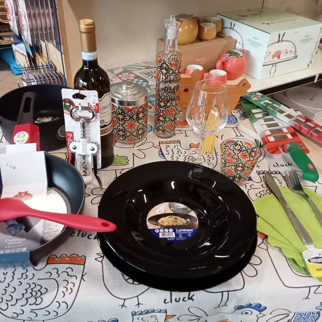 Un tavolo con una pila di piatti neri e una bottiglia di vino