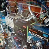 Un mucchio di mulinelli da pesca sono appoggiati uno sopra l'altro su un tavolo.