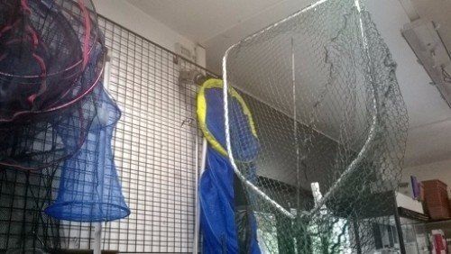 Una rete da pesca è appesa al muro di un negozio.