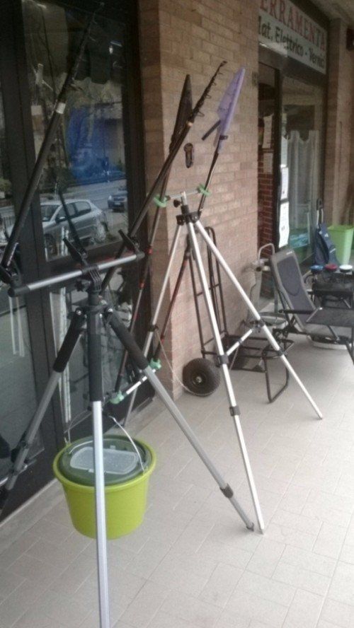 Un secchio è appoggiato su un treppiede davanti a un negozio.