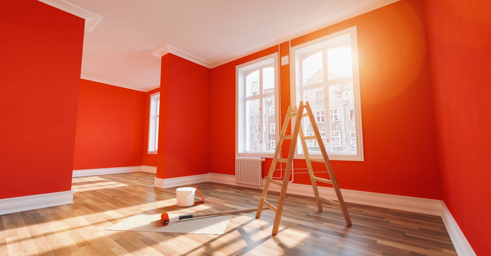 Room with red painted wall, partially painted gray wall, doorway, ladder, and wooden floor.