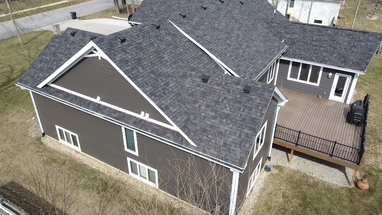 Dark gray house with a brown exterior and a deck.