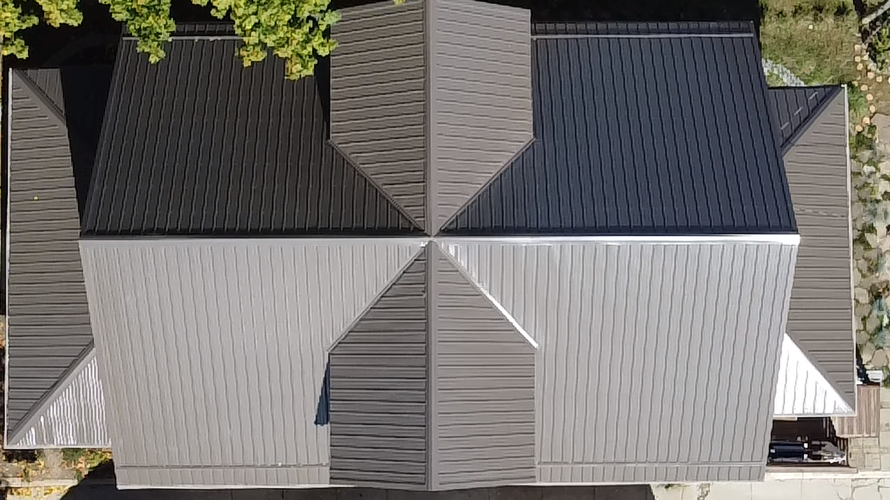 Overhead view of a house roof, divided into four sections of gray and black shingles.