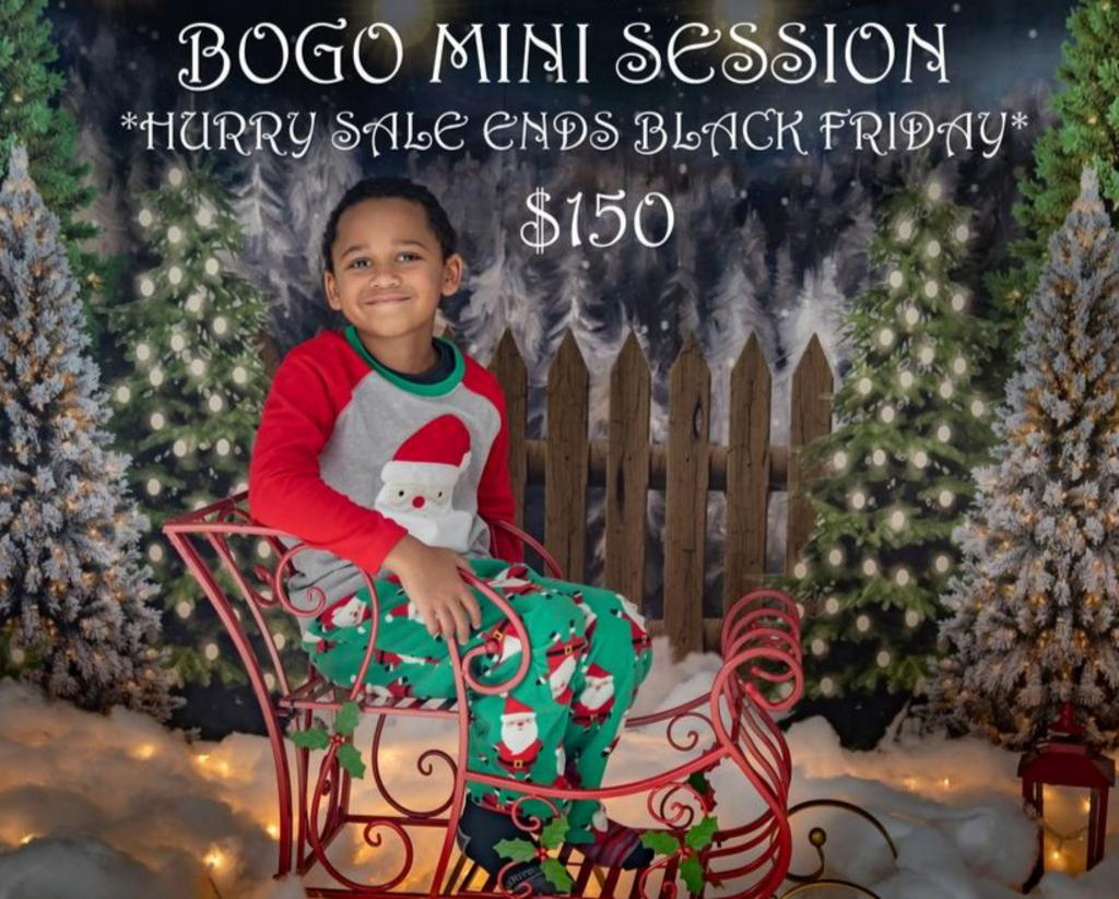 A little boy is sitting in a sleigh in front of a sign that says bogo mini session.