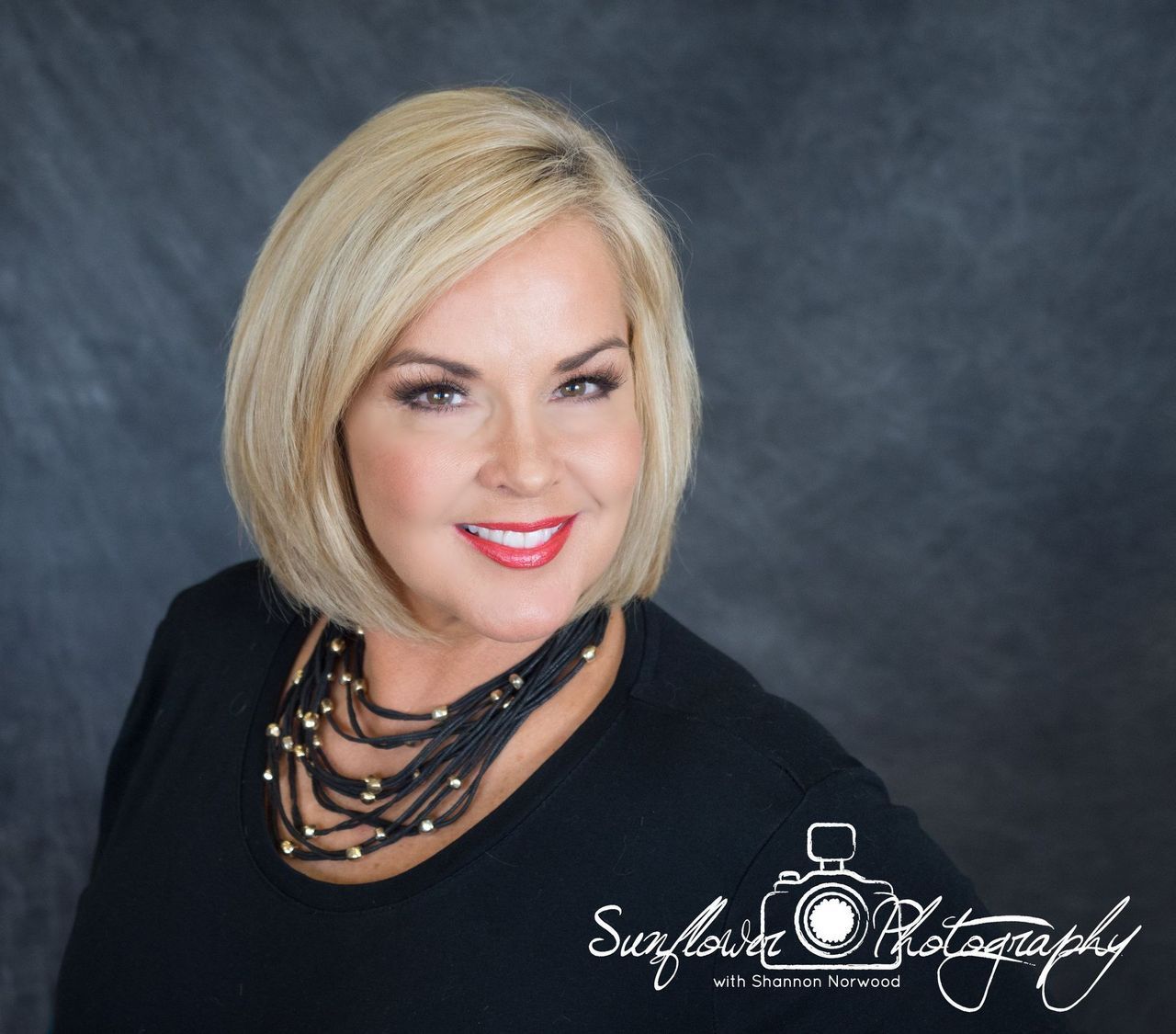 A woman wearing a black shirt and a black necklace is photographed by sunflower photography
