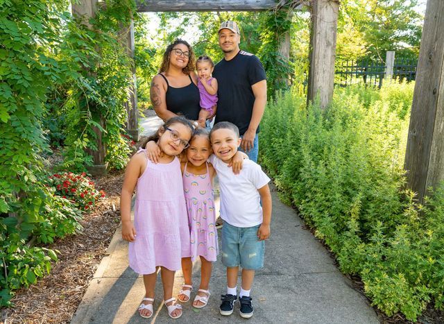 A family is posing for a picture in a park.