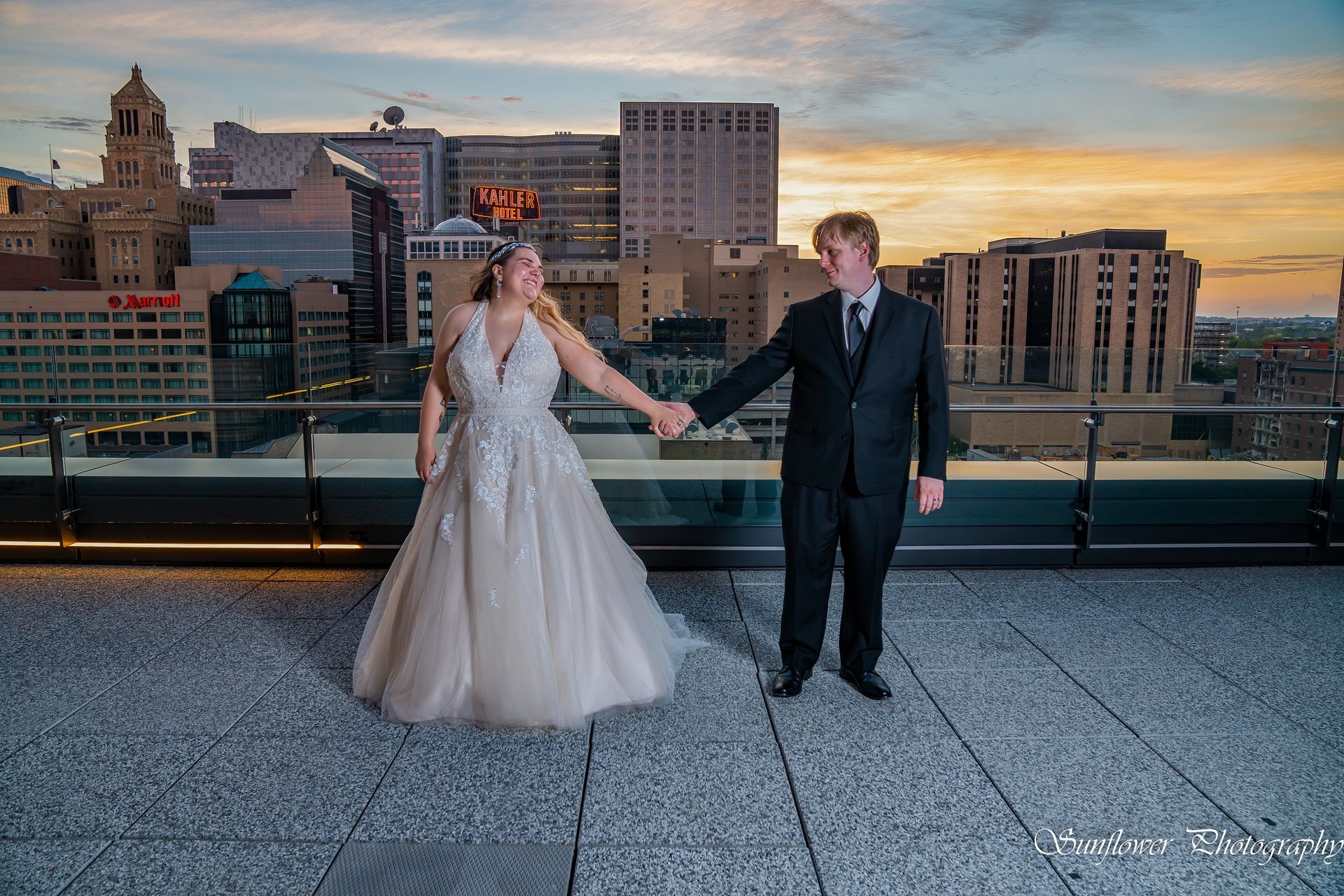 A bride and her flower girl are posing for a picture in the grass.