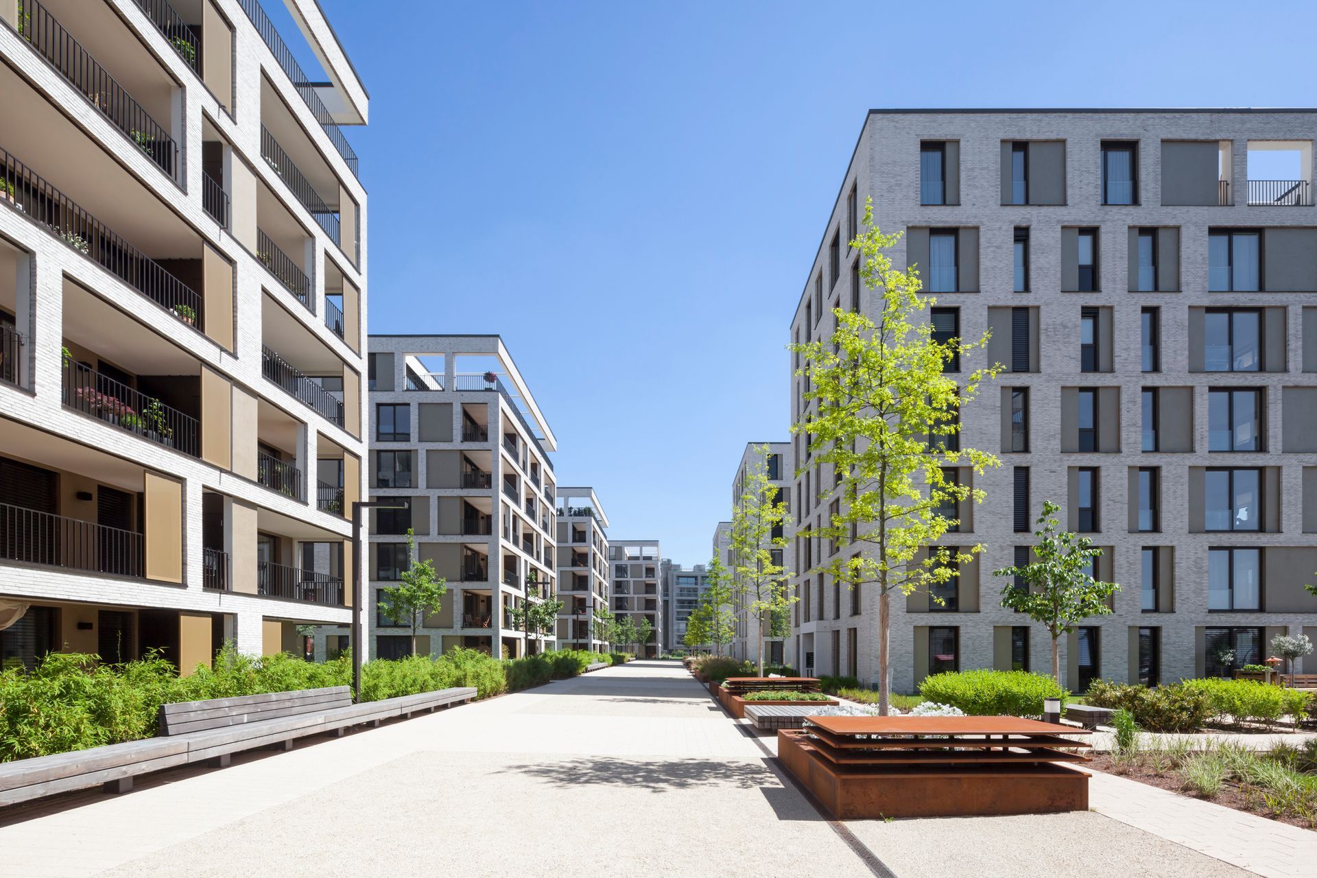A tall building with a lot of windows is surrounded by trees.