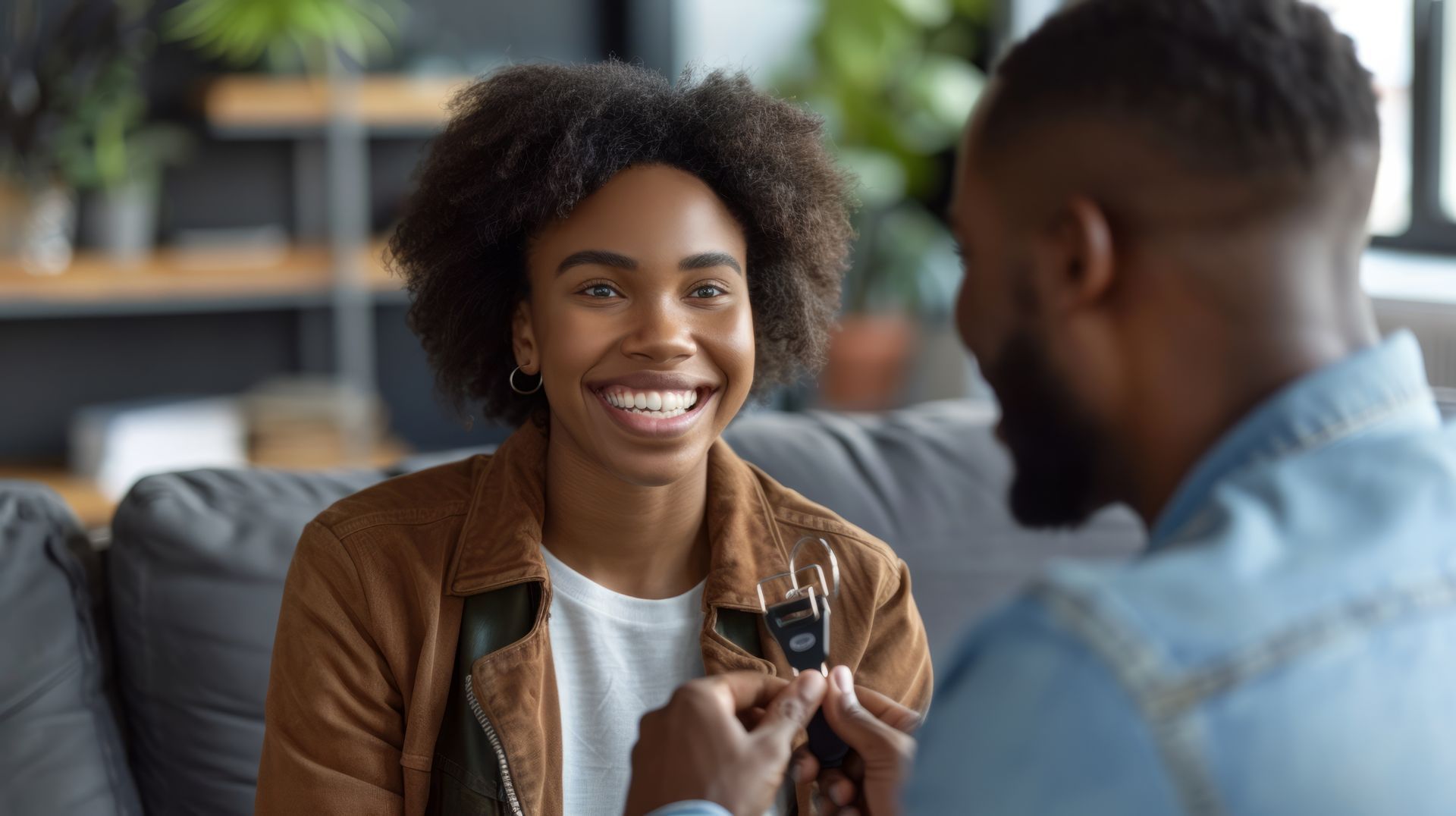 A man in a hard hat is talking to a woman and a man in front of a house under construction.
