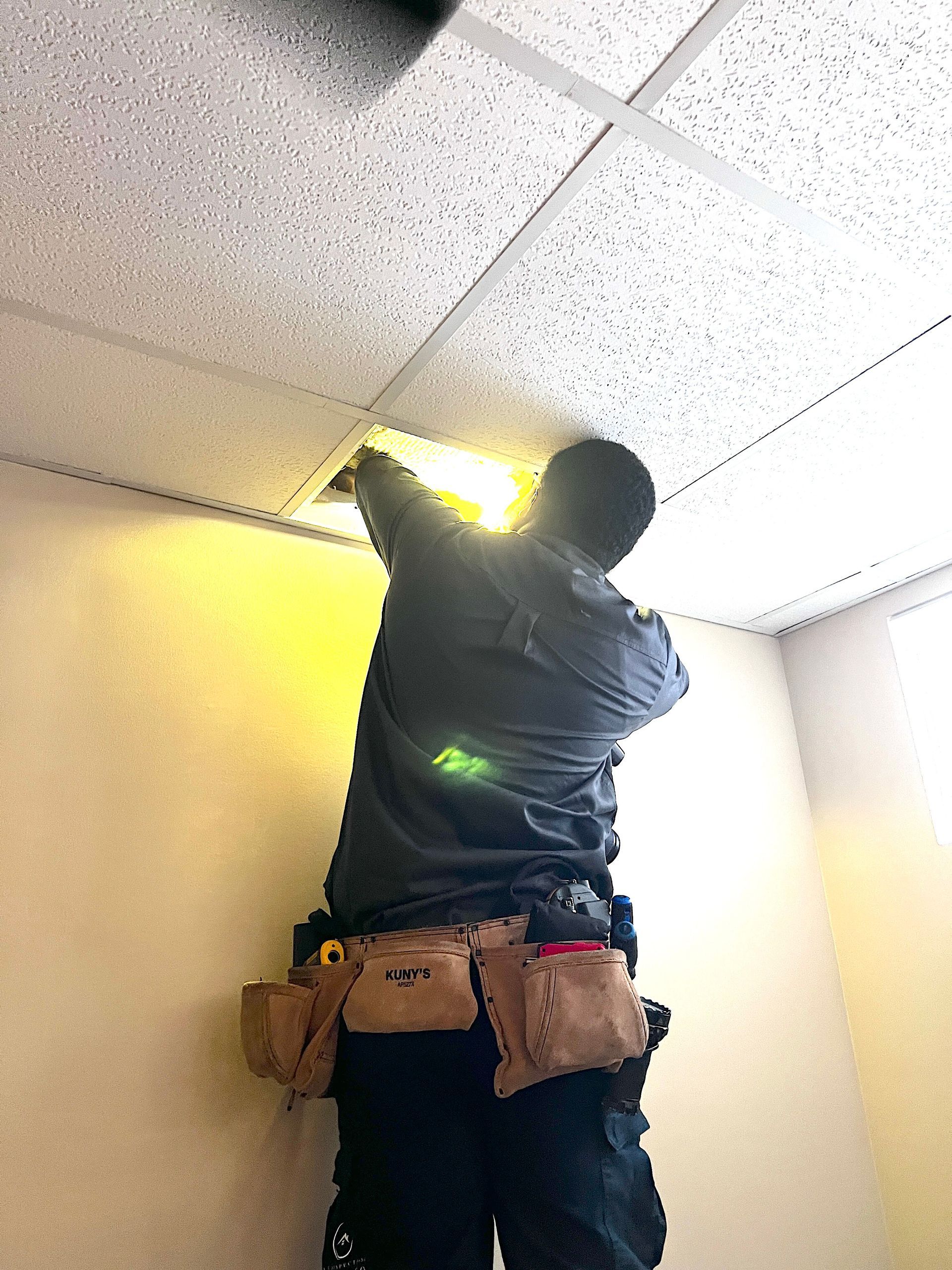Un homme travaille sur le plafond d'une pièce.