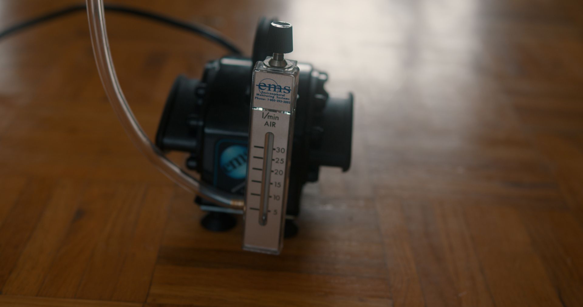 A model house is sitting on top of a pile of coins next to a calculator.