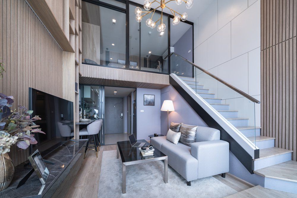 A living room with a couch and stairs leading up to the second floor.