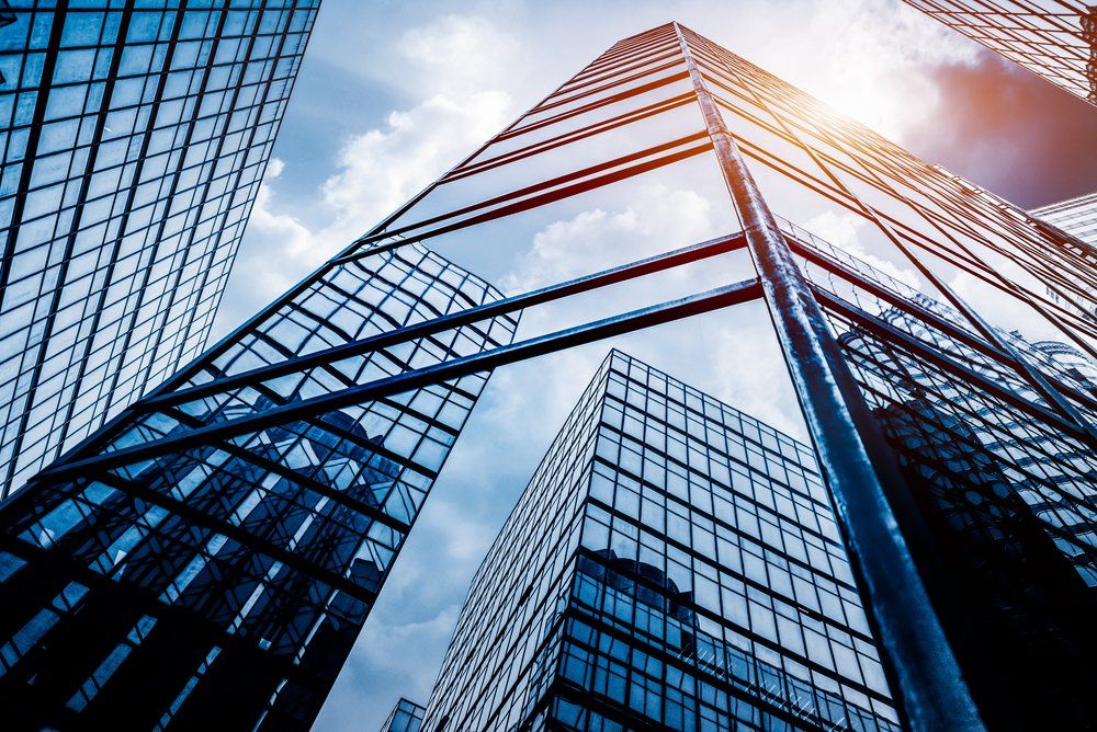 Looking up at a group of tall buildings with a blue sky in the background.