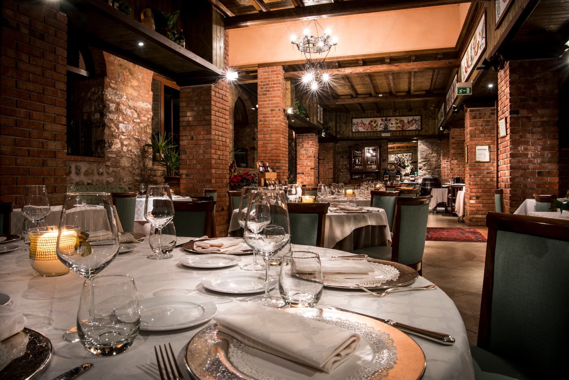 Tavoli all'aperto apparecchiati per una festa con vista sul mare al tramonto.