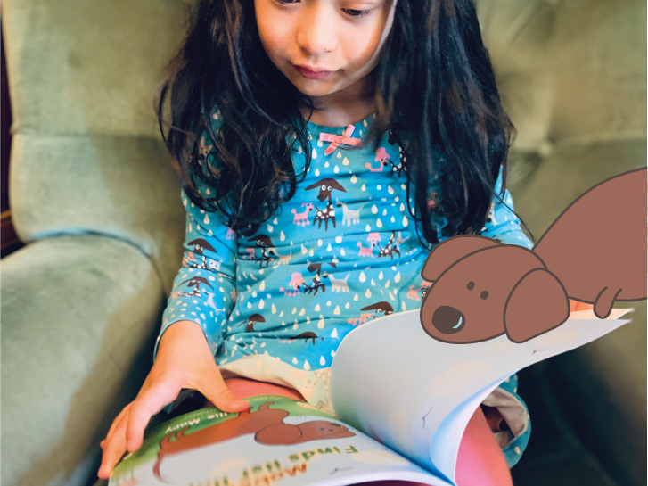 A little girl is sitting in a chair reading a book