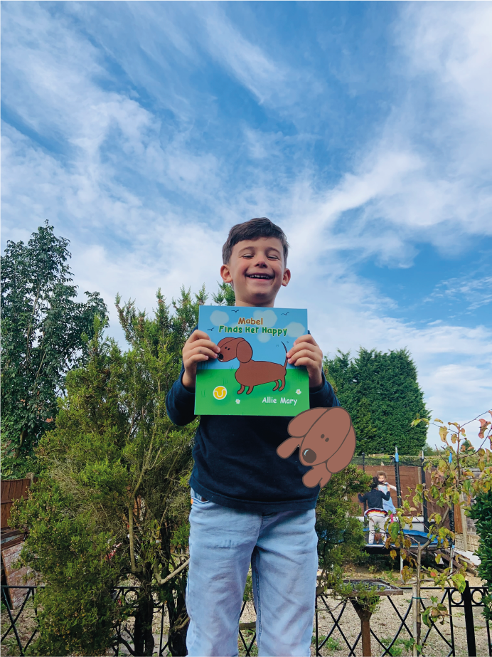 A young boy is holding a book with a picture of a dog on it