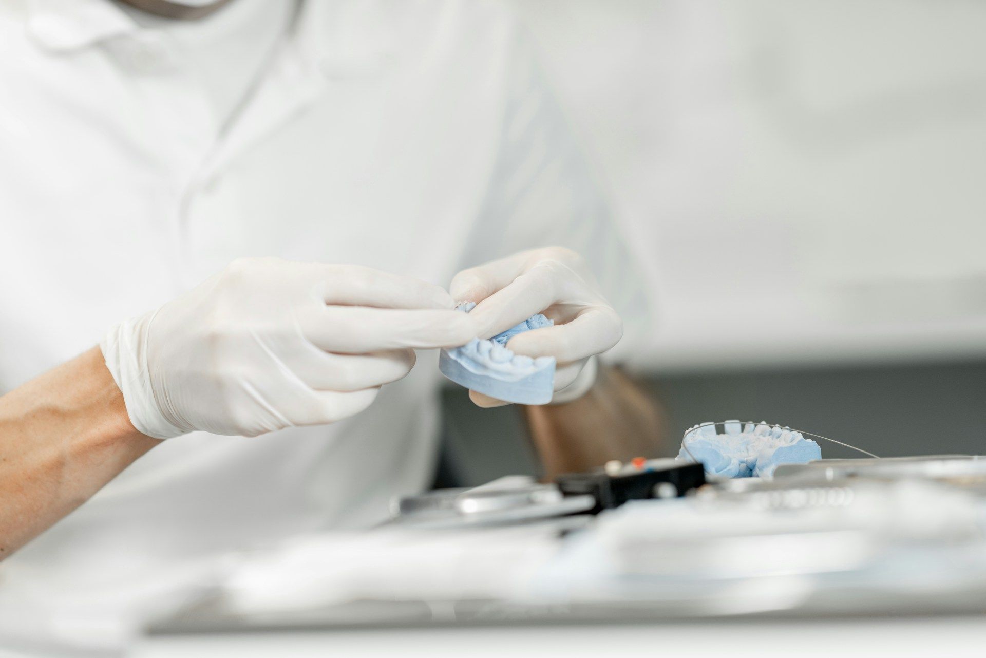 A dentist is holding a model of a tooth in his hands.