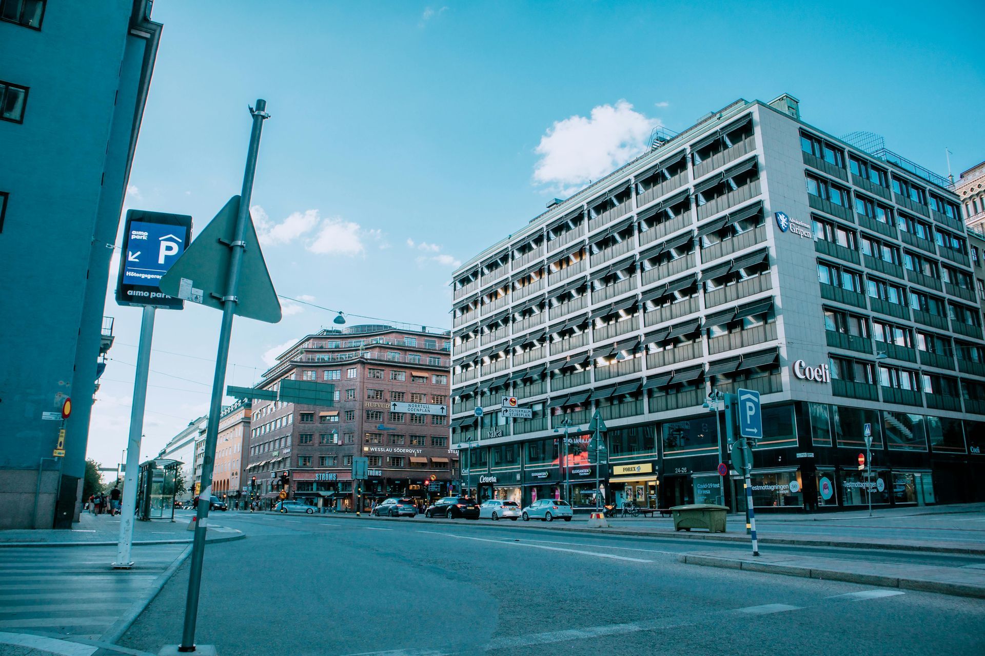 Two individuals hold hands, their fingers interlaced, set against a softly blurred natural outdoor background.