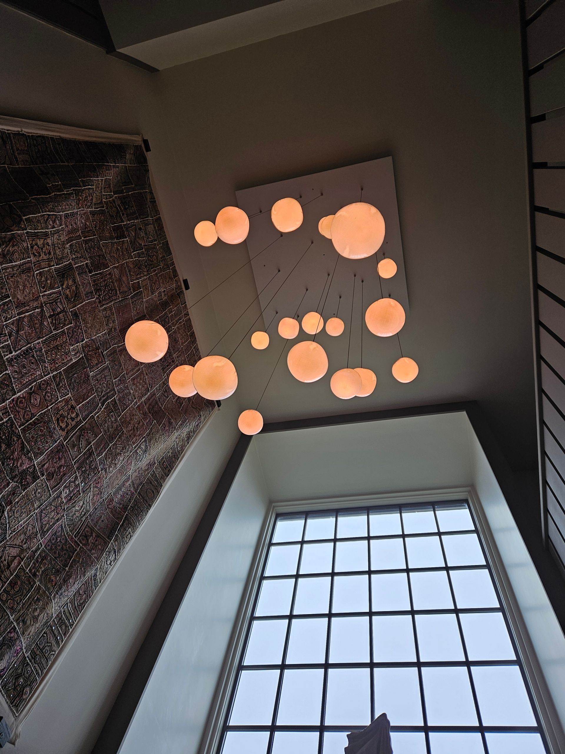 Looking up at a ceiling with lots of lights hanging from it