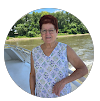 A woman is standing next to a body of water in a circle.